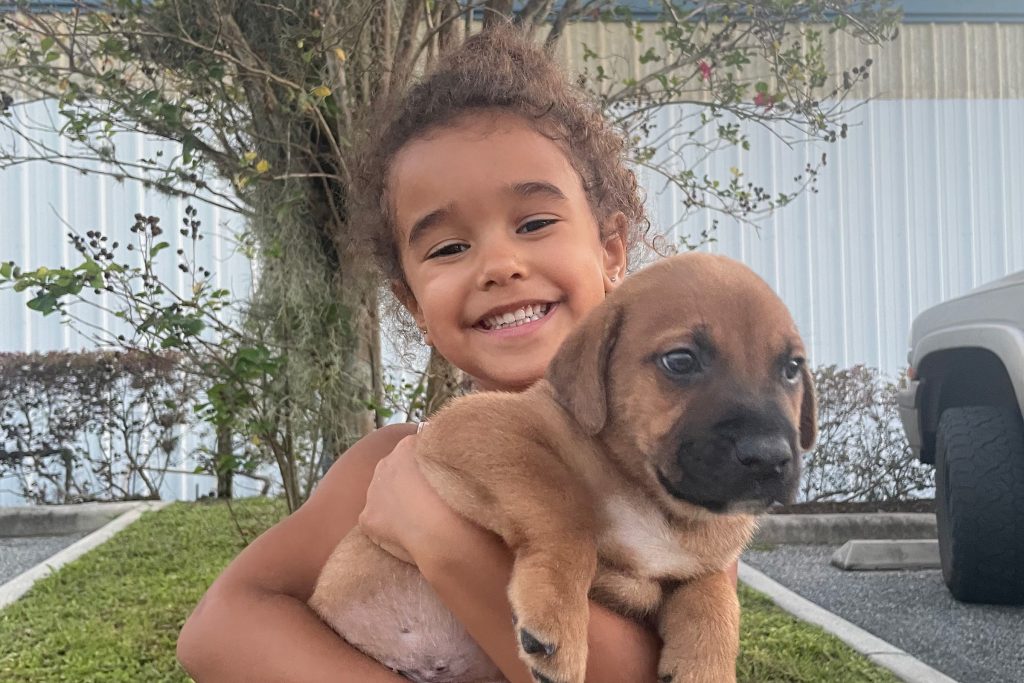 Healthy Charlee held by neighbor Sophia, 5