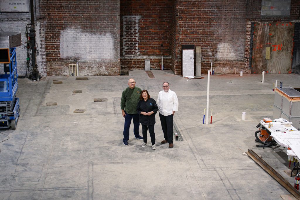three people inside building that's ready for renovation