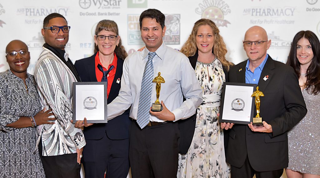 smiling people holding awards