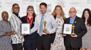 smiling people holding awards