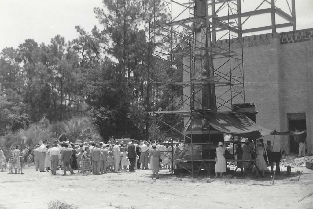 black and white photo of people gathered outside sanctuary construction