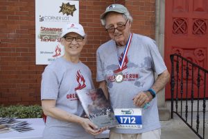 Jacksonville History Center’s Kate Hallock presents Hank Coxe, representing sponsor The Bedell Firm, with a copy of the book, “The Great Fire of 1901.”