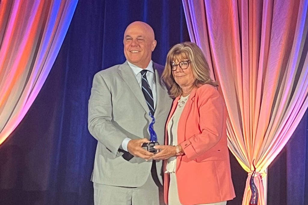 Florida Blue/GuideWell President and CEO Pat Geraghty presents Sulzbacher President and CEO Cindy Funkhouser with a Sapphire Award.