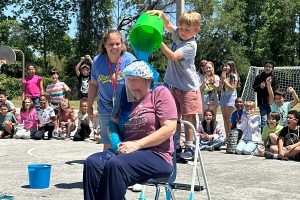 Stockton first grader Antonio C. dumps a bucket of slime on Principal Stephanie Brannan.
