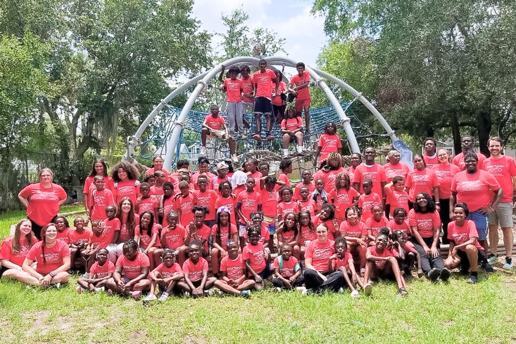 A group of The Sanctuary on 8th Street’s 2025 campers and coaches pose for a group photo.