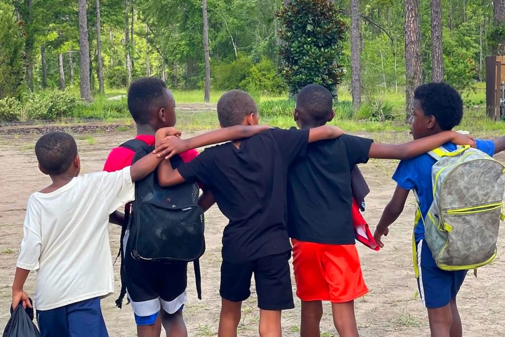 group of boys walking with hands on each other's shoulders