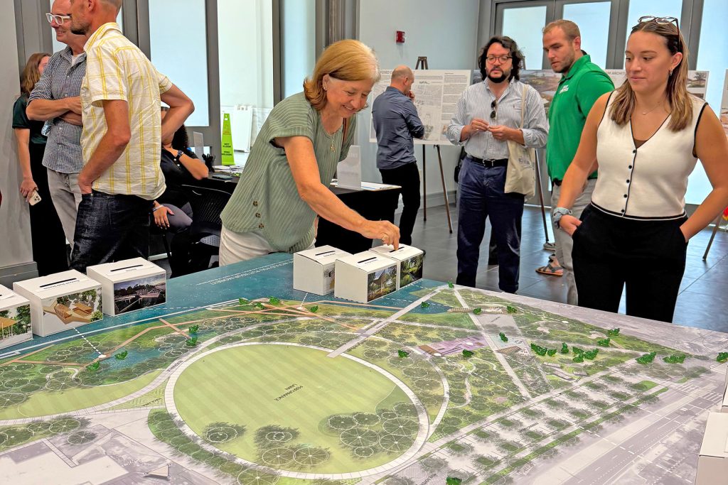 Sandy Arpin drops a coin into the box for “The Ramble,” one of the additional amenities that could be included in the revitalized Metropolitan Park.