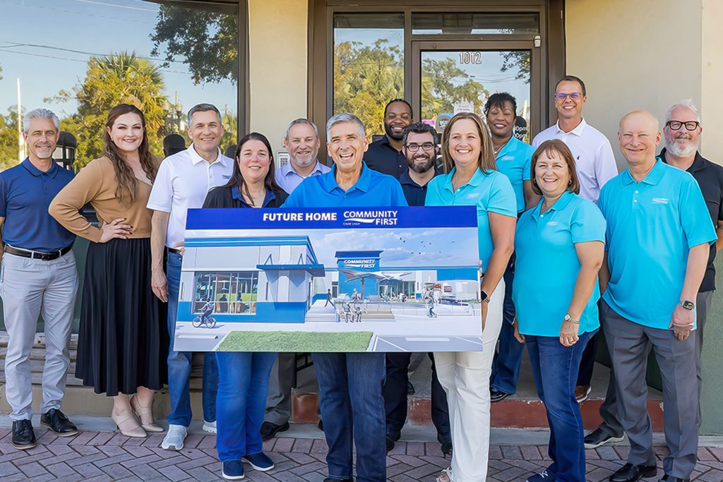 Community First Credit Union President and CEO Sam Inman holds a rendering of the incoming Murray Hill branch, joined by Community First team members.