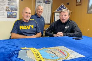 Ship Manager and Retired Navy Captain James F. Fossa with William Harrell and Dan Bean at the table in the USS Orleck’s wardroom, where the Turkish Navy embroidered cover is on display.
