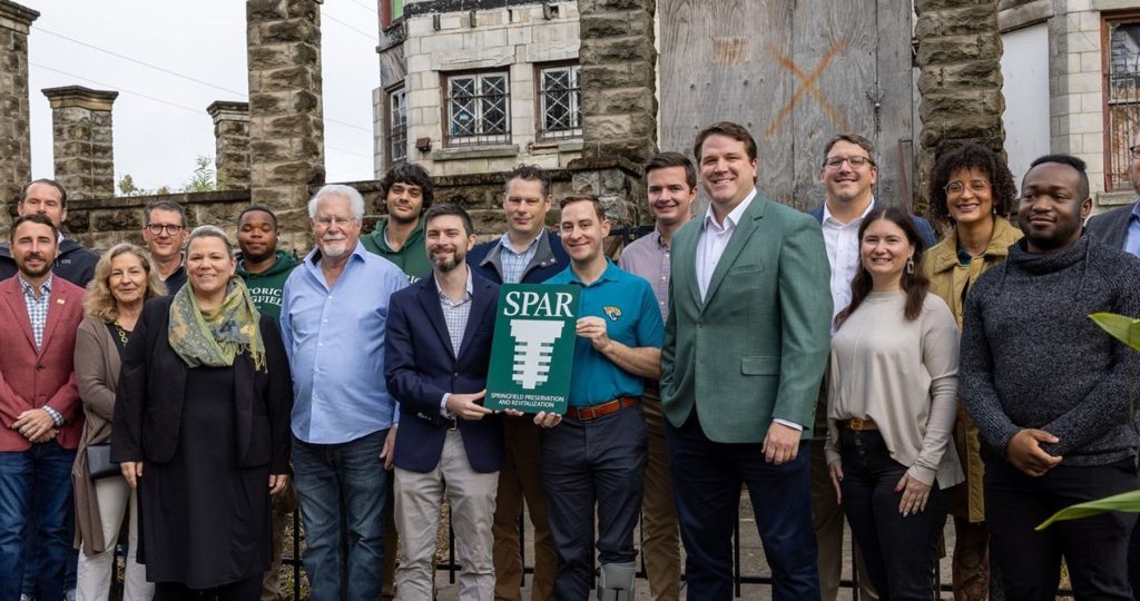 SPAR Executive Director Michael Haskins stands center with District 7 City Councilmember Jimmy Peluso, joined by other city and community stakeholders, at the Dec. 8 press conference announcing SPAR’s acquisition of the Drew Mansion.