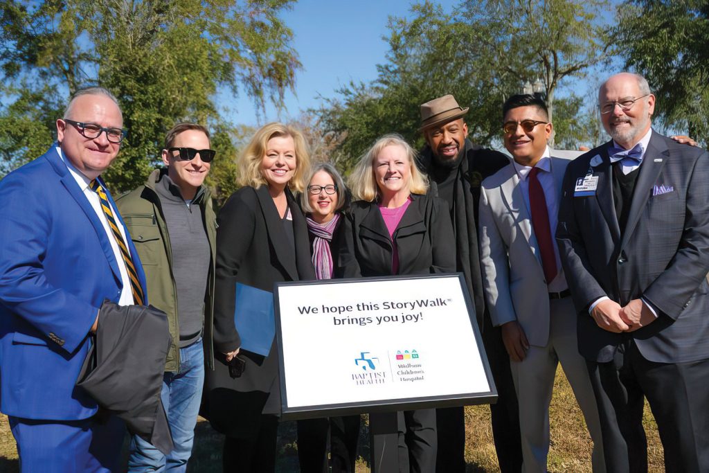 Katie Ensign, middle, with community and city leaders and Baptist Health
former CEO Michael A. Mayo (right) at the unveiling of the StoryWalk,® which is included in LaVilla Link, the first phase of Emerald Trail