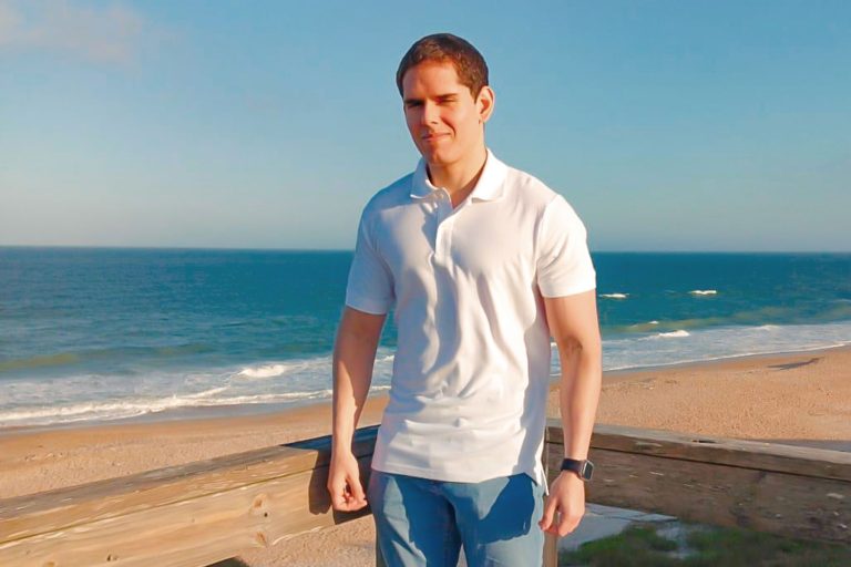 Ariel Alberto Montero Valera in a polo and jeans, with a beach view in the background