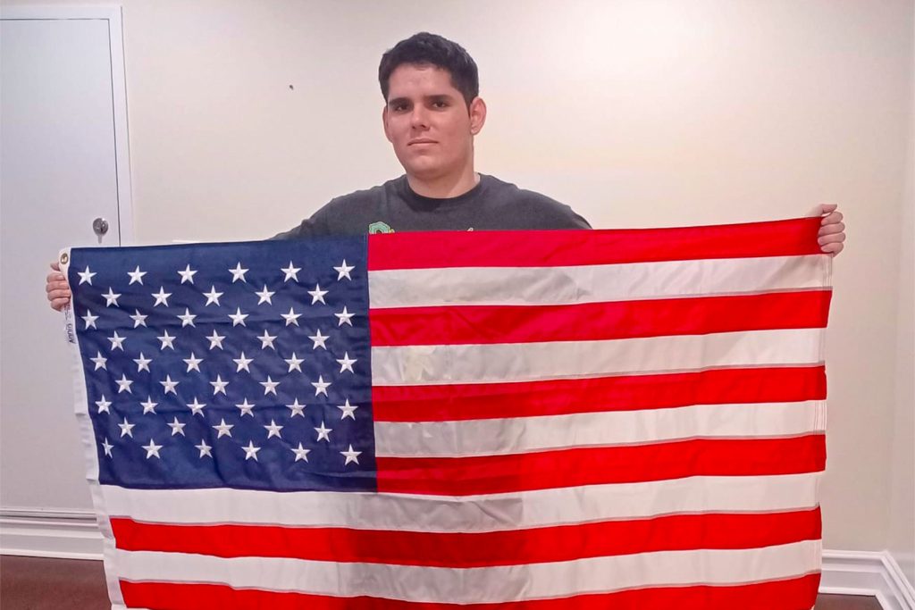 Ariel Alberto Montero Valera holding up an American Flag
