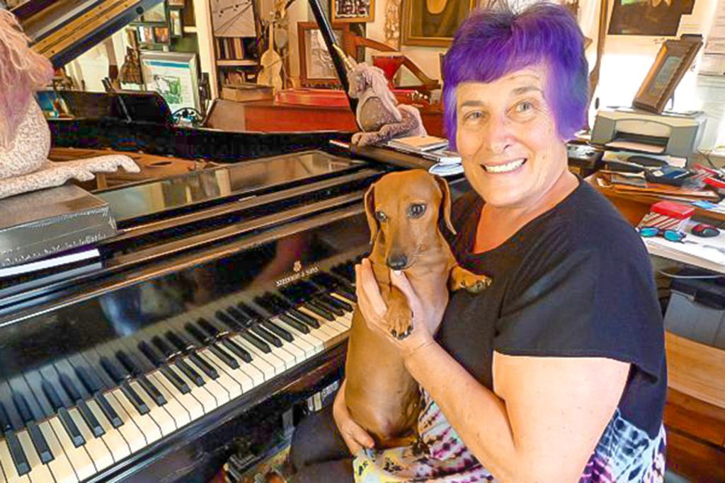 Martinelli at a piano with her dog