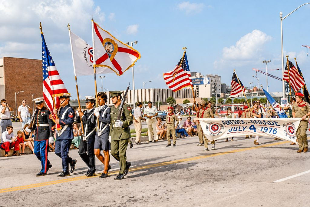 What’s a parade without its flag bearers? A solemn line-up marches down Coastline Drive in the July 4, 1976 parade. | Photo: Nancy Gandy